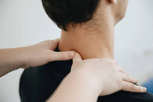 Fisioterapeuta masajeando el cuello de una paciente en camilla