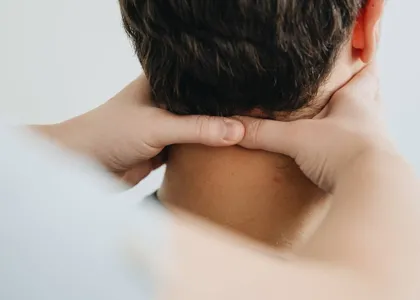 Manos de un fisioterapeuta tratando la nuca y el cuello de un paciente