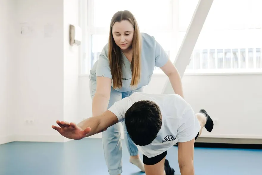 Fisioterapeuta guiando un ejercicio a un paciente