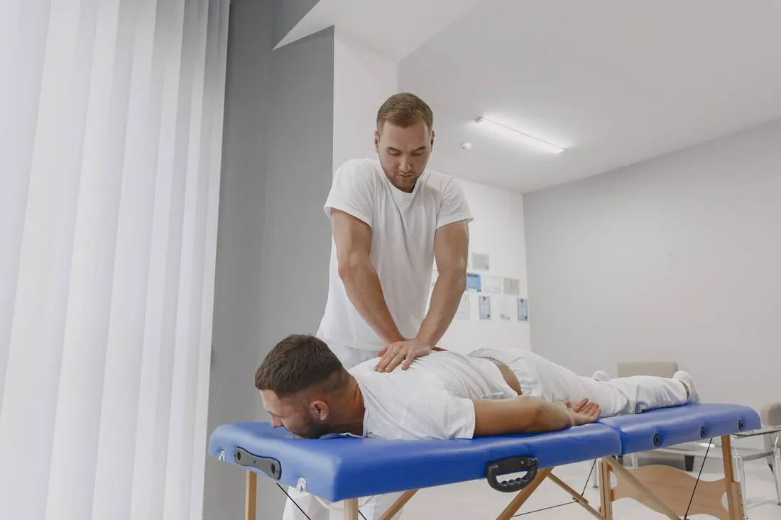Fisioterapeuta tratando la espalda de un paciente tumbado en camilla
